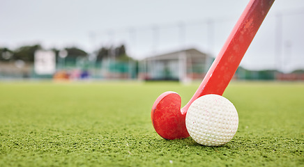 Image showing Field, sports and a ball and a stick for hockey, fitness and training in the morning. Closeup, ground and gear or equipment for a competition, game or tournament at a stadium or turf on bokeh