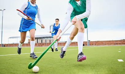 Image showing Sports, fitness and female hockey athletes playing game, match or tournament on an outdoor field. Equipment, exercise and young women training or practicing for strategy with stick and ball on pitch.