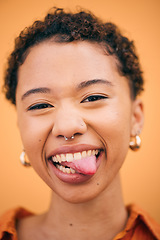 Image showing Happy, woman and tongue out portrait in studio with smile and confidence feeling silly. Orange background, young and African female person with trendy, modern and student fashion with gen z piercing