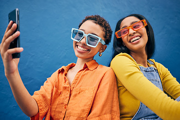 Image showing Selfie, fashion and women in city with phone for social media, internet post and profile picture. Friends, influencer and female people relax in urban town with trendy sunglasses on blue background