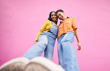 Image showing Selfie, fashion and portrait of friends on pink background in city with trendy clothes, stylish and cool outfit. Happy, creative and below of female people for freedom on holiday, vacation or weekend