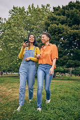 Image showing Women, park and girl friends on walk outdoor with laugh, bonding and friendship in nature. Urban, city garden and phone with gen z, young and female people on holiday with freedom and happy in spring