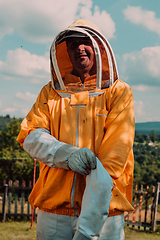 Image showing Beekeeper put on a protective beekeeping suit and preparing to enter the apiary