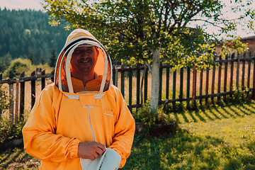 Image showing Beekeeper put on a protective beekeeping suit and preparing to enter the apiary