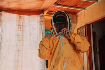 Image showing Beekeeper put on a protective beekeeping suit and preparing to enter the apiary