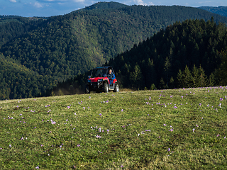 Image showing A man driving a quad ATV motorcycle through beautiful meadow landscapes