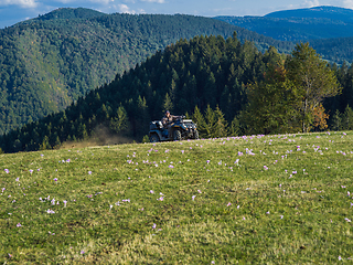 Image showing A man driving a quad ATV motorcycle through beautiful meadow landscapes