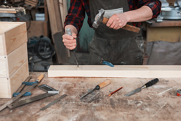 Image showing The worker makes measurements of a wooden board