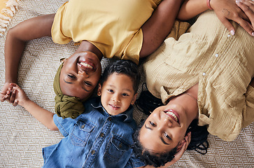 Image showing LGBT, happy portrait and relax family, child or people care, smile and lesbian bond together, lying and on floor carpet. Mothers face, top view kid and non binary parents, homosexual mom or gay women