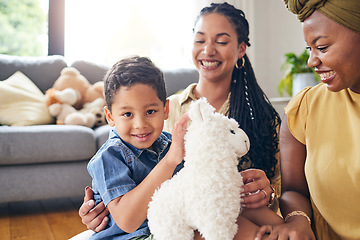 Image showing Portrait, gay family and child with a teddy bear on a home floor for development, fun and smile. Adoption, lesbian or LGBT women or parents and kid together in a lounge while playing with toys