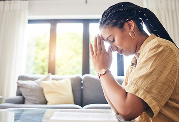 Image showing Bible, worship and woman praying in her living room for hope, help or forgiveness at home. Hands, book and Christian female in prayer for blessing, grace and gratitude to Jesus Christ or God in house