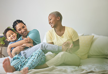 Image showing Morning, gay family and hug on bed in home bedroom for security, quality time and love. Adoption, lesbian or LGBTQ women or parents and a happy foster kid together to wake up with care and fun play