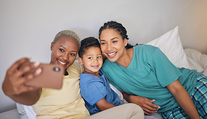 Image showing Gay, happy family and selfie in bed with foster boy child and relax at home. Adoption, lesbian couple and lgbt women on social media, smile for profile picture, blog or post in bedroom on the bed