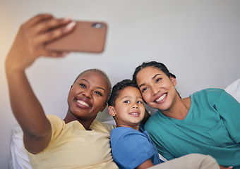 Image showing Gay family, happy and selfie in bed with foster boy child, bond and relax at home. Adoption, lesbian women and social media lgbt influencer smile for profile picture, blog or podcast post in bedroom