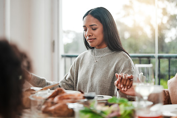 Image showing Woman, praying and holding hands at family dinner at thanksgiving celebration at home. Food, female person and eyes closed at a table with religion, lunch and social gathering on holiday in house