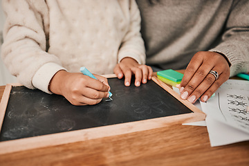 Image showing Hands, writing and mom with child on home, table for remote learning, education or drawing on chalkboard or desk in house. Helping, teaching and creative kid with chalk and support from parent