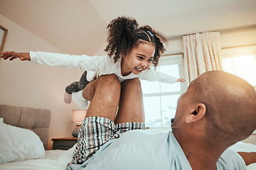 Image showing Dad, child and playing airplane on bed flying for fun, quality time or bonding together in home, bedroom or girl in the air. Happy, father and daughter balance on knees with arms raised and freedom