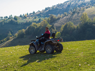 Image showing A man driving a quad ATV motorcycle through beautiful meadow landscapes