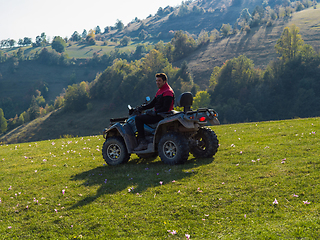 Image showing A man driving a quad ATV motorcycle through beautiful meadow landscapes