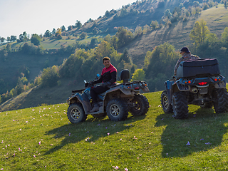 Image showing Adventurous driving of ATV motorbikes. Two man driving a quad bike on dangerous roads