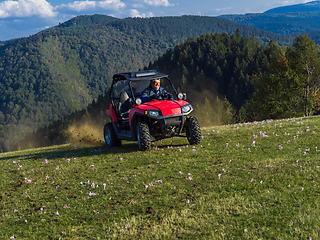 Image showing A man driving a quad ATV motorcycle through beautiful meadow landscapes