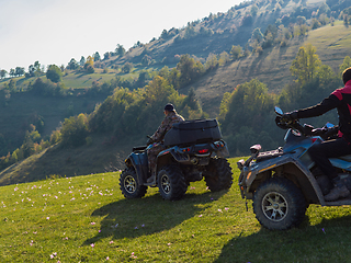 Image showing A man driving a quad ATV motorcycle through beautiful meadow landscapes