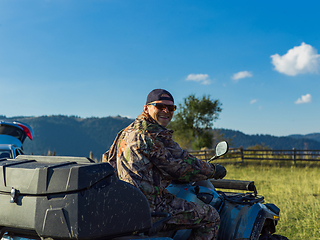 Image showing A man driving a quad ATV motorcycle through beautiful meadow landscapes