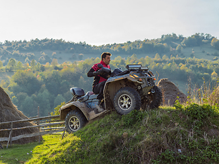 Image showing A man driving a quad ATV motorcycle through beautiful meadow landscapes