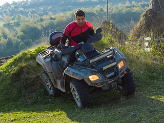 Image showing A man driving a quad ATV motorcycle through beautiful meadow landscapes