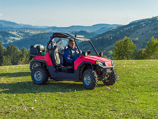 Image showing A man driving a quad ATV motorcycle through beautiful meadow landscapes