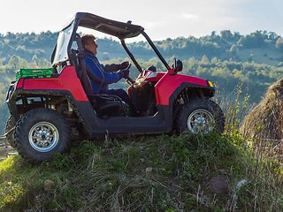 Image showing A man driving a quad ATV motorcycle through beautiful meadow landscapes