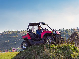 Image showing A man driving a quad ATV motorcycle through beautiful meadow landscapes