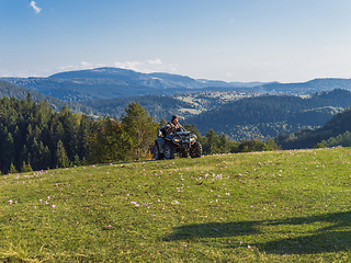 Image showing A man driving a quad ATV motorcycle through beautiful meadow landscapes