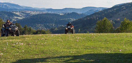 Image showing A man driving a quad ATV motorcycle through beautiful meadow landscapes