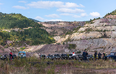 Image showing A group of men on a social gathering are preparing to ride an ATV quad bike. People Ride together on a quad atv on muddy forest roads