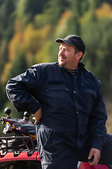 Image showing A man in a forest area posing next to a quad and preparing for ride