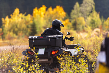 Image showing A man driving a quad ATV motorcycle through beautiful meadow landscapes