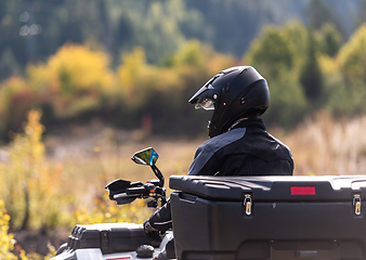 Image showing Adventurous driving of ATV motorbikes. A man drives a quad bike on dangerous roads