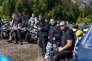 Image showing A group of men on a social gathering are preparing to ride an ATV quad bike. People Ride together on a quad atv on muddy forest roads