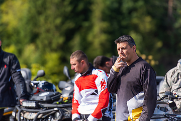 Image showing A group of men on a social gathering are preparing to ride an ATV quad bike. People Ride together on a quad atv on muddy forest roads