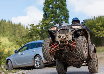 Image showing Adventurous driving of ATV motorbikes. A man drives a quad bike on dangerous roads