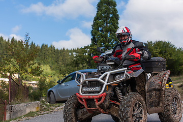 Image showing Adventurous driving of ATV motorbikes. A man drives a quad bike on dangerous roads