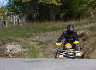 Image showing Adventurous driving of ATV motorbikes. A man drives a quad bike on dangerous roads