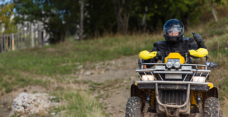 Image showing Adventurous driving of ATV motorbikes. A man drives a quad bike on dangerous roads