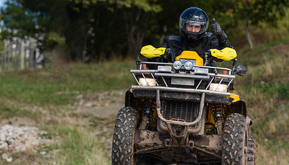 Image showing Adventurous driving of ATV motorbikes. A man drives a quad bike on dangerous roads