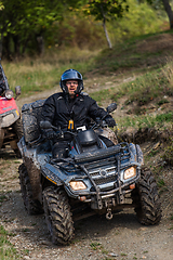 Image showing Adventurous driving of ATV motorbikes. A man drives a quad bike on dangerous roads