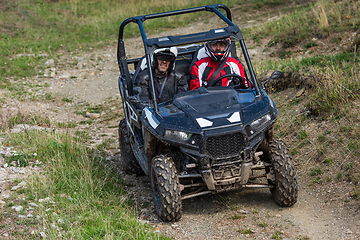 Image showing A man driving a quad ATV motorcycle through beautiful meadow landscapes