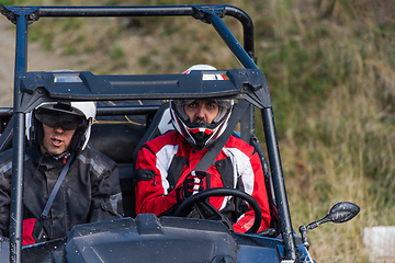 Image showing A man driving a quad ATV motorcycle through beautiful meadow landscapes