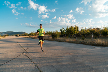 Image showing Triathlete in professional gear running early in the morning, preparing for a marathon, dedication to sport and readiness to take on the challenges of a marathon.