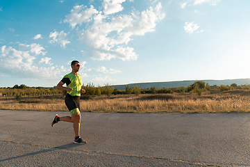 Image showing Triathlete in professional gear running early in the morning, preparing for a marathon, dedication to sport and readiness to take on the challenges of a marathon.